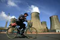 Un hombre pasa en bicicleta frente a las torres de enfriamiento de una planta eléctrica que trabaja con carbón en Fuxin, población ubicada en la provincia china de Liaoning. China podría convertirse en 2009 en el primer emisor de gases de invernadero, principales causantes del calentamiento global, superando a Estados Unidos. El presidente chino Hu Jintao llega esta semana a la cumbre del G-8 con su país en el centro de varias polémicas, tanto de tipo comercial como financiero