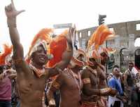 Un grupo de manifestantes vestidos de gladiadores romanos bailan al pasar frente al Coliseo