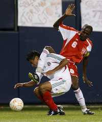 Singular manera del caribeño Alain Vertot de frenar al atacante mexicano Alberto Medina, durante una jugada del primer tiempo