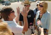 La activista por la paz Cindy Sheehan (derecha), conversa con un residente en Montgomery, Alabama, durante un encuentro con los reporteros frente a la sede del Congreso local, durante una caravana contra la guerra en Irak que partió hace 13 días del rancho del presidente George W. Bush en Crawford, Texas