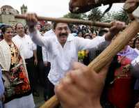 El gobernador Ulises Ruiz lucha con un hombre que representa a un toro durante la realización del convite a la Guelaguetza, frente al templo de Santo Domingo