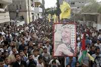 Palestinos cargan en la ciudad de Gaza un cartel con la figura de Yasser Arafat, ayer durante una marcha por el tercer aniversario de la muerte del presidente de la ANP