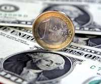 Una moneda de un euro y un billete de un dólar. La moneda europea ha llegado a paridad récord con la moneda estadunidense debido a las expectativas sobre el crecimiento de la economía de Estados Unidos