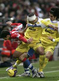 El jugador de Atlético de Madrid, Maxi Rodríguez, a la izquierda, en duelo por el balón contra Cata Díaz, en el centro, y Rubén de La Red, a la derecha, del Getafe, durante su encuentro de la Liga Española en el estadio Vicente Calderón de Madrid