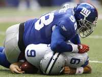 Antonio Pierce, linebacker de Gigantes, somete a Tony Romo, quarterback de Vaqueros