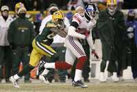 Un mal pase de Brett Favre, de Green Bay, permitió que Corey Webster (derecha) interceptara el envío a Donald Driver en el tiempo extra