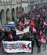 Cientos de personas se manifestaron en Berna, Suiza, en contra del Foro Económico Mundial; en la manta se lee: "UBS (Banco Unido de Suiza) mil millones en la arena, WEF (Foro Económico Mundial) miles de millones en la nieve. El futuro, en nuestras manos"