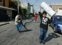 Vecinos de la colonia Valle del Sur, de la delegación Iztapalapa, llenan con agua cubetas y cisternas, tras la reducción del suministro en la ciudad. Varias pipas de la demarcación se han dado a la tarea de surtir el líquido en la zona