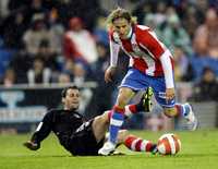 El colchonero Diego Forlán elude a Pablo Orbaiz, del Athletic de Bilbao