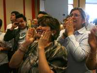 En imagen de la oficina de prensa del Palacio de Miraflores, familiares de los cuatro políticos liberados ayer por la guerrilla colombiana observan por televisión el momento de la entrega, desde el aeropuerto de la ciudad venezolana de Maiquetia