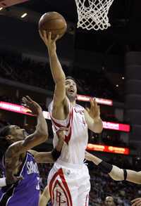 El argentino Luis Scola de los Rockets de Houston burla la marca de Mikki Moore de los Kings para lograr el enceste