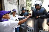 Intercambio de flores por sonrisas, ayer, durante el plantón que las adelitas defensoras del petróleo nacional instalaron en las cercanías de la Cámara de Senadores