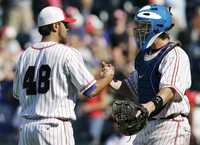 Joakim Soria, pitcher de los Reales de Kansas City es felicitado por el catcher John Buck después de la victoria sobre los Gigantes