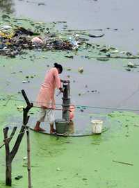 Una niña bombea agua después de las intensas lluvias que hace dos semanas cayeron en Allahabad, India, uno de los países que serán foco de atención en el foro que realiza la OMS en Singapur