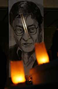 Las llamas iluminan la fotografía del poeta palestino Mahmoud Darwish en la ciudad de Ramallah, donde decenas de personas se reunieron sosteniendo velas y sollozando tras el fallecimiento del escritor, de 67 años, considerado el "poeta de la resistencia palestina"