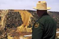 James Swanson, supervisor de operaciones especiales de la Patrulla Fronteriza, observa a un grupo de trabajadores que rellenan la llamada Barranca del Contrabandista cerca de los límites con México en el área de San Diego, California; con maquinaria pesada se inició el relleno del profundo cañón el viernes para proveer una base para el levantamiento de la cerca fronteriza en esa zona tras 12 años de planeación, revisiones ambientales y procesos legales