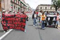 Integrantes del Comité Nacional de Familiares de Desaparecidos Políticos, del Frente Estudiantil Revolucionario y del Frente Nacional Contra la Represión, ayer, durante su marcha por la avenida Madero, frente al palacio de gobierno, en Morelia. Los manifestantes portaron mantas con consignas y fotos de los activistas sociales desaparecidos y exigieron el cese de la represión