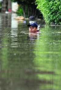 Las partes bajas de Minatitlán, Veracruz, permanecen bajo el agua que subió hasta un metro, debido al desbordamiento del río Coatzacoalcos, por lo que las personas afectadas han sido auxiliadas con lanchas y helicópteros. En la imagen, un habitante de la colonia Payón