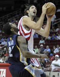 El argentino Luis Scola, de los Rockets de Houston, recibió una falta de O. J. Mayo, de los Grizzlies de Memphis, durante el juego de pretemporada que ganaron los texanos 96-93