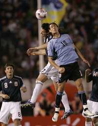 El uruguayo Edison Cavani (derecha) cabecea el balón antes que el argentino Nicolás Burdisso, en duelo que la albiceleste ganó 2-1, dentro de las eliminatorias mundialistas