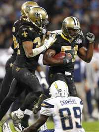 Jonathan Vilma y Mike McKenzie, de los Santos de Nueva Orléans, celebran la cuarta intercepción al mariscal de campo de San Diego, Chris Chambers, ayer, en el estadio Wembley, Londres