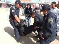 Martín Lozano Gutiérrez, subdirector técnico operativo de la policía de Ecatepec, es auxiliado por otros uniformados, durante el zafarrancho entre choferes de transporte público y locatarios de la Central de Abasto de Ecatepec, estado de México