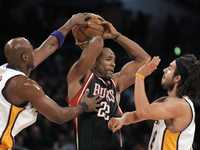 El defensa Michael Redd (22), de los Bucks, es acosado por los delanteros Lamar Odom, a la izquierda y Sasha Vujacic, a la derecha, de los Lakers de Los Ángeles