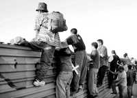 Desde la barrera fronteriza, migrantes observan por vez primera territorio estadunidense, tras una marcha contra la política de Washington en la materia. Imagen de archivo