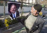 Un simpatizante de las Guardias Revolucionarias iraníes golpea un afiche con la figura del presidente estadunidense George W. Bush, ayer en Teherán, durante una manifestación contra Estados Unidos