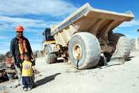 Un trabajador de una de la empresas subcontratadas por Goldcorp posa con su hijo al lado de un vehículo utilizado para remover escombros. En Peñasquito se usa la técnica de tajo abierto, una de las más dañinas para el medio ambiente