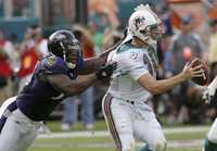 El quarterback de Miami, Chad Pennington (10), es detenido por Terrell Suggs, de Baltimore