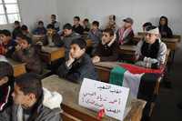 Una bandera palestina y un cartel con el nombre de Muhammed Elabsi, muerto  durante los bombardeos israelíes, al reiniciarse las clases en Rafah