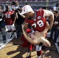 Alan Branch, tacle de Cardenales, baila con Renee Sapp durante el Dia de Prensa del Supertazón 43 de la NFL