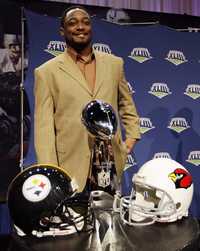 Mike Tomlin, de Acereros, y Ken Whisenhut, de Cardenales, posan para la tradicional placa con el trofeo Vince Lombardi