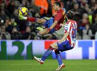 El brasileño Daniel Alves, quien anotó un gol en la victoria del Barcelona 3-1 sobre el Sporting de Gijón, es marcado por Raúl Cámara