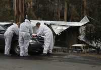 Investigadores forenses trabajan cerca de los restos de una casa arrasada por el fuego en Kinglake, 46 kilómetros al norte de Melbourne